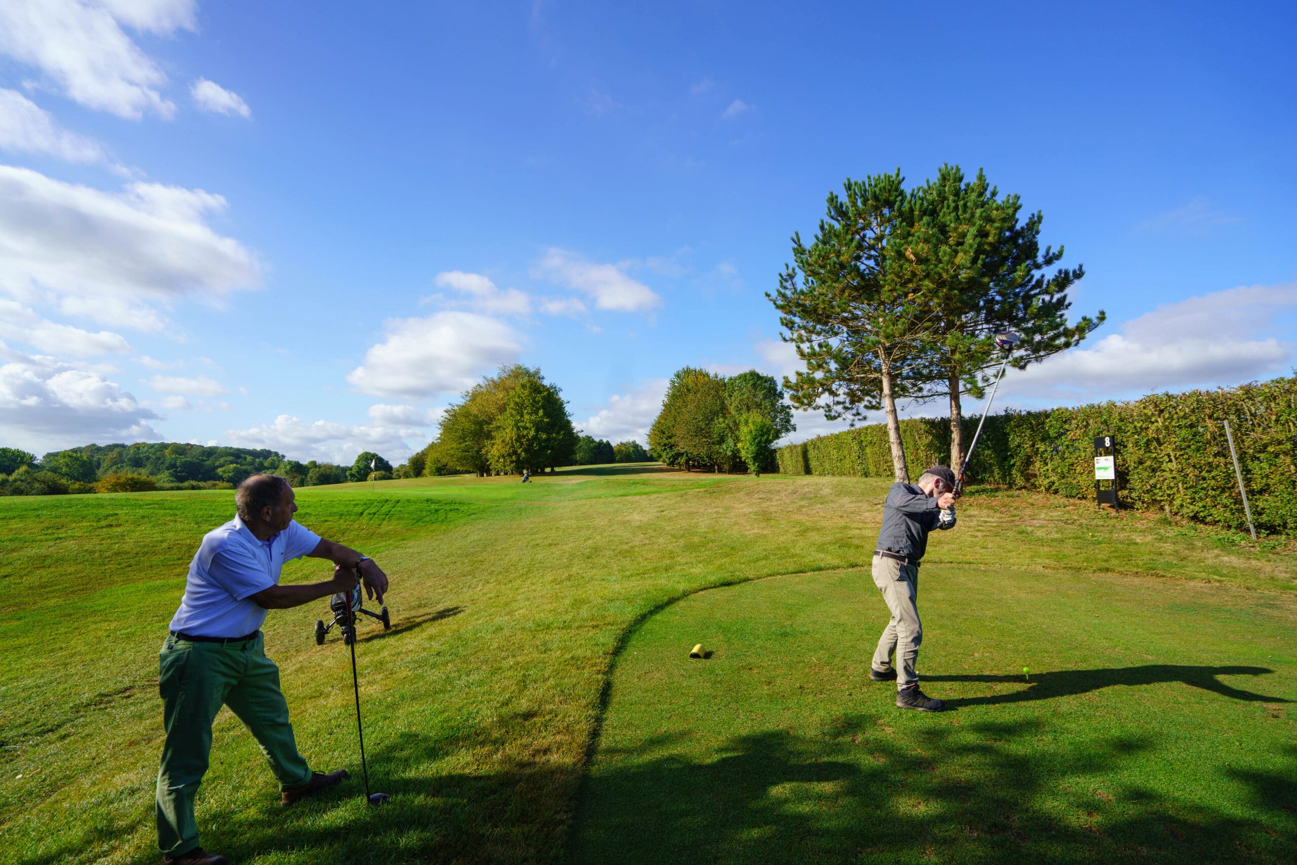 Golf de Falnuée, avec un golfeur en action entouré de figurants, capturant l'énergie du parcours et l'atmosphère conviviale d'une journée de golf.