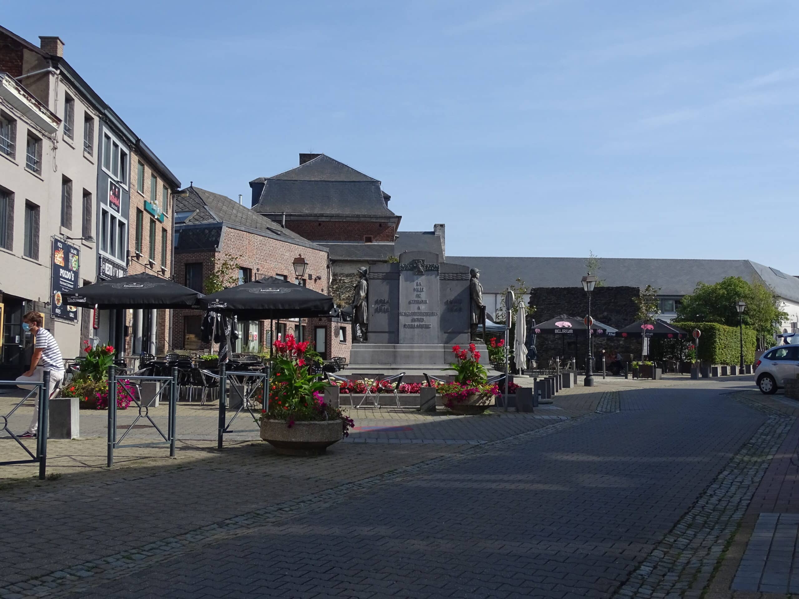 Place Saint-Jean en été, animée par les terrasses des cafés et l'atmosphère chaleureuse de la ville.