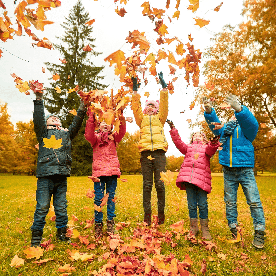 Enfants qui lancent des feuilles en automne